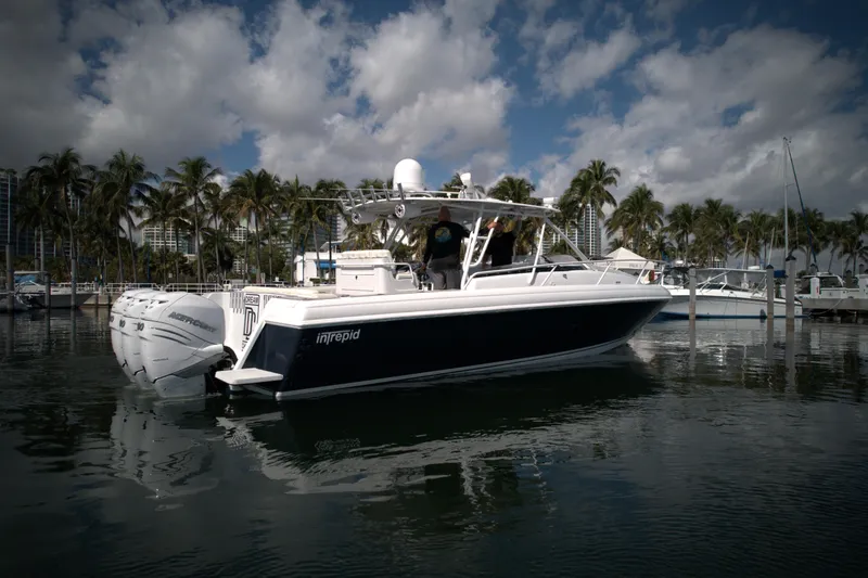 Slide: The Image of 2002 Intrepid 377 Walkaround Cuddy boat docked in a marina with palm trees. - 12