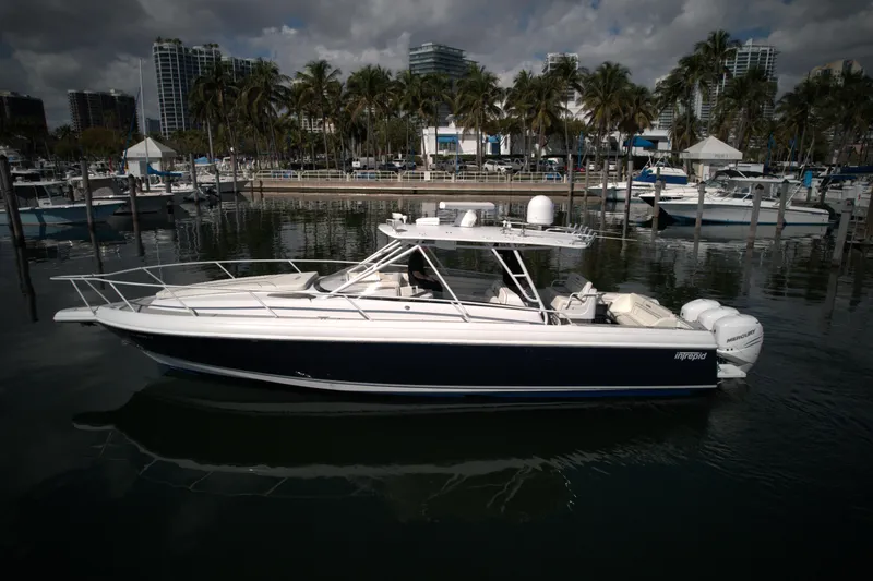 Slide: The Image of 2002 Intrepid 377 Walkaround Cuddy boat docked in a marina. - 2