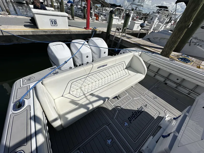 Slide: The Image of 2002 Intrepid 377 Walkaround Cuddy boat with triple outboard engines docked at marina. - 29