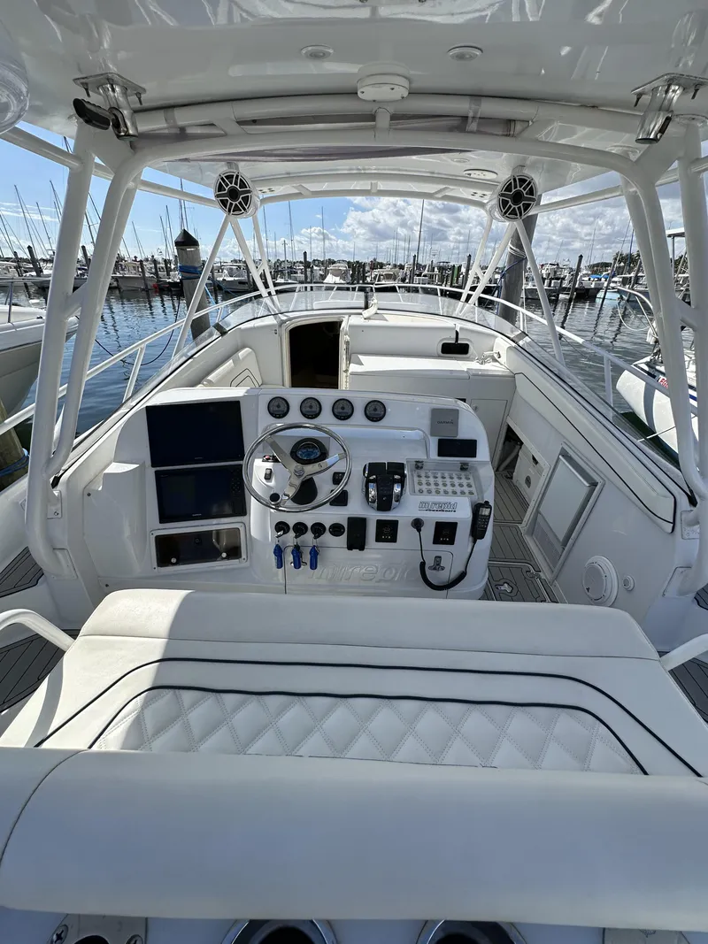 Slide: The Image of 2002 Intrepid 377 Walkaround Cuddy boat cockpit with modern controls and marina background. - 31
