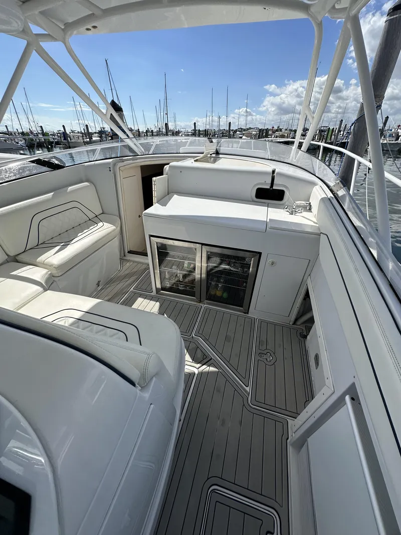 Slide: The Image of 2002 Intrepid 377 Walkaround Cuddy interior with seating and storage, docked at marina. - 34