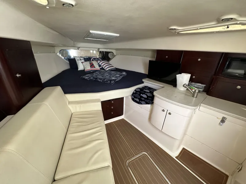 Slide: The Image of 2002 Intrepid 377 Walkaround Cuddy interior with bed, sofa, and kitchenette. - 38