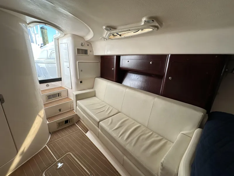 Slide: The Image of Interior of 2002 Intrepid 377 Walkaround Cuddy with white leather sofa and wooden cabinets. - 40