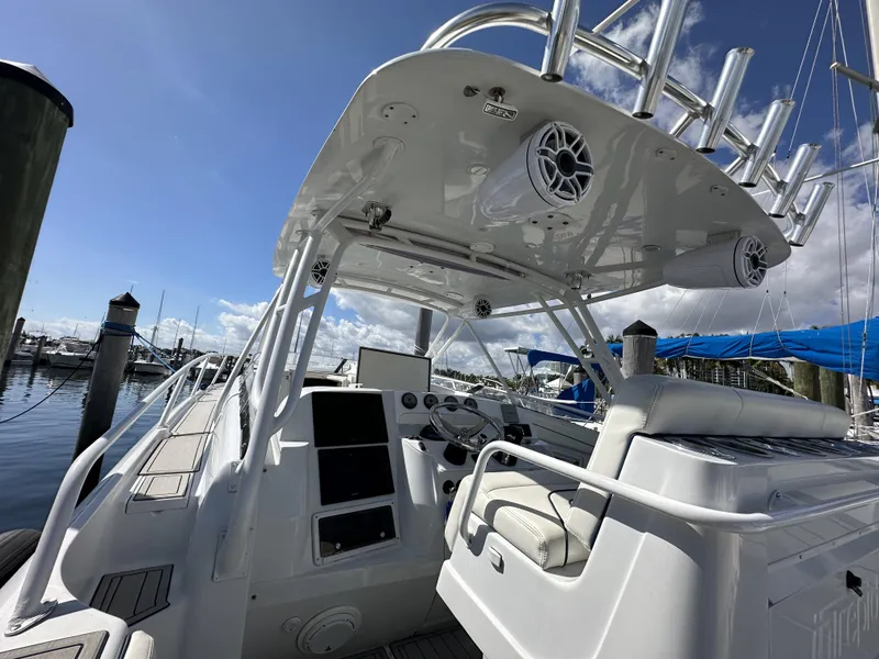 Slide: The Image of 2002 Intrepid 377 Walkaround Cuddy boat docked at a marina, featuring a spacious helm. - 48