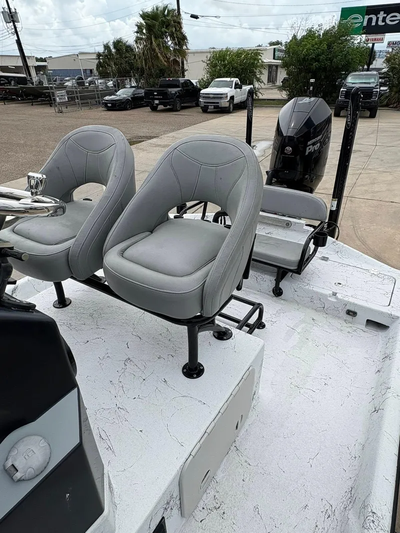 Slide: The Image of 2022 Shoalwater 21 Catamaran with dual seats and outboard motor in a parking lot. - 11