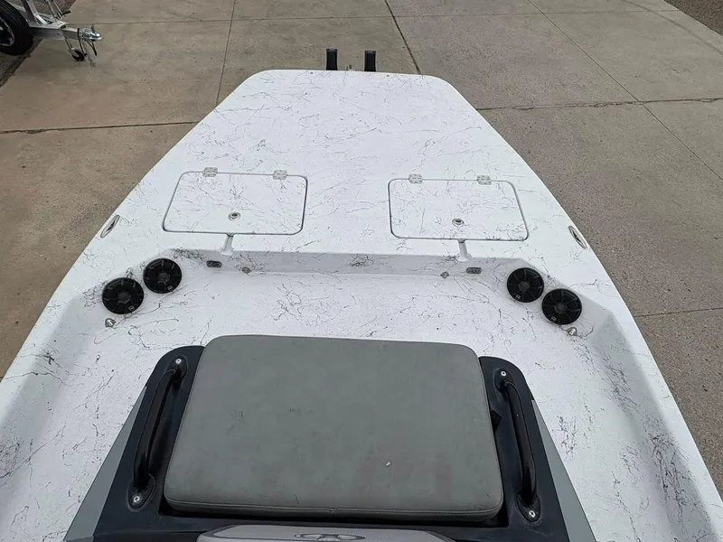 Slide: The Image of 2022 Shoalwater 21 Catamaran deck with storage hatches and speakers, parked on concrete. - 12