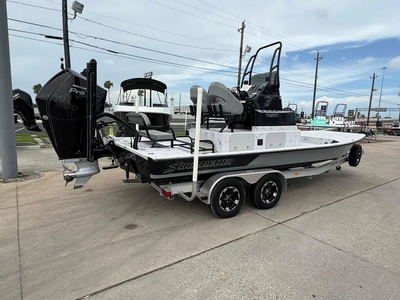 Slide: The Image of 2022 Shoalwater 21 Catamaran boat on trailer, featuring dual engines, parked outdoors. - 2