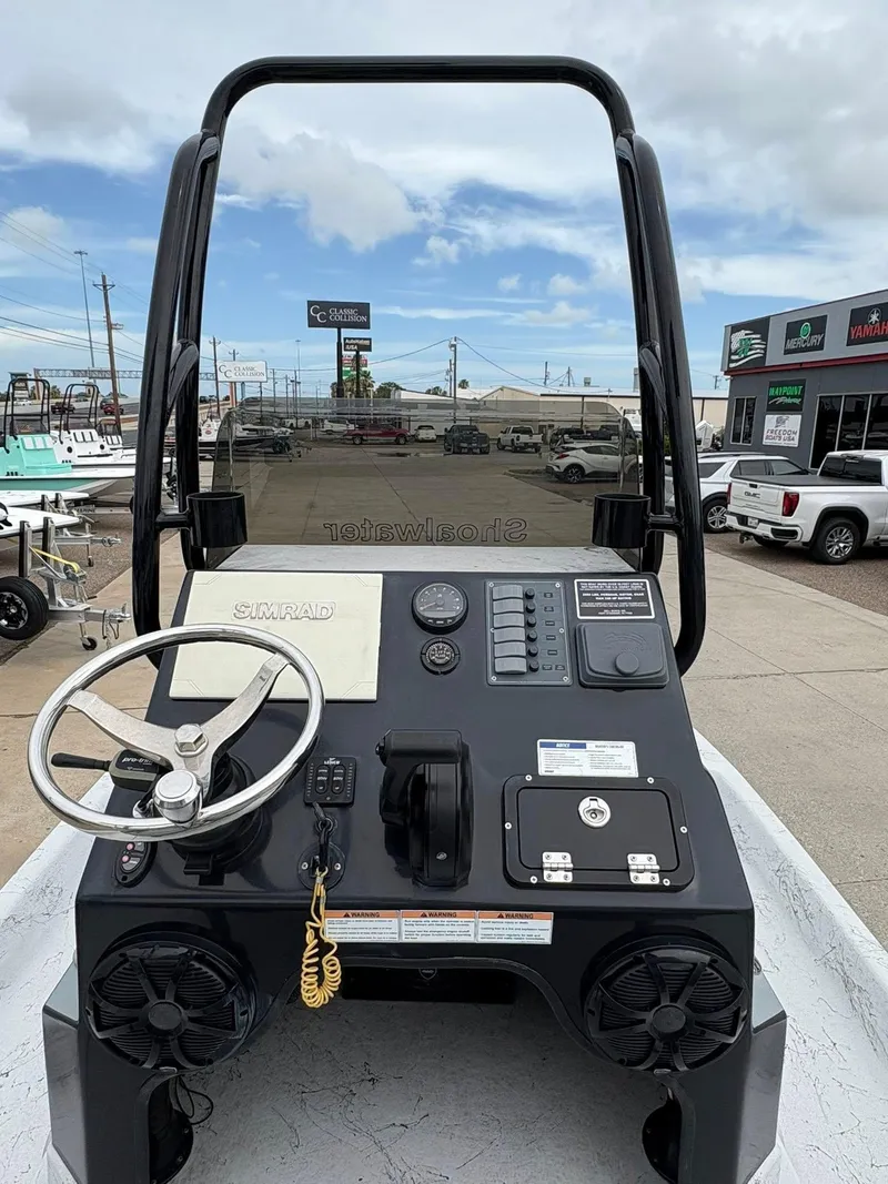 Slide: The Image of 2022 Shoalwater 21 Catamaran dashboard with steering wheel and controls, parked outdoors. - 5