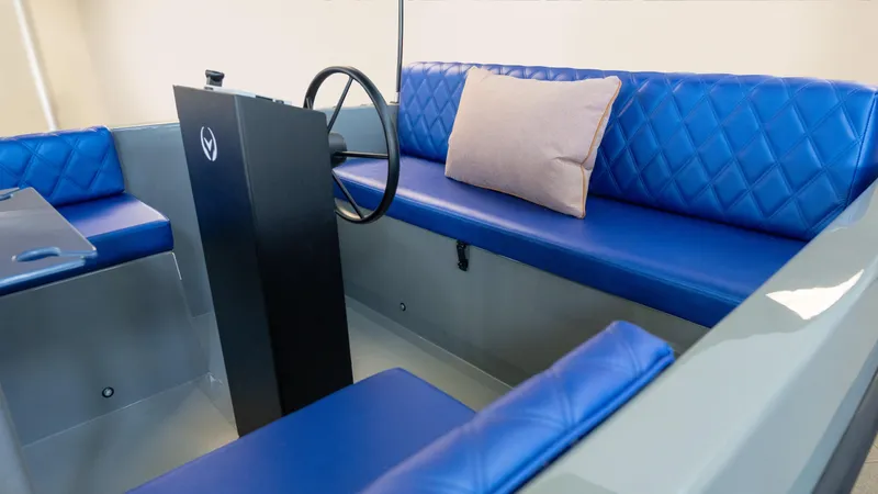 Slide: The Image of 2023 Vision Marine Technologies Volt 180 interior with blue seating and steering console. - 6