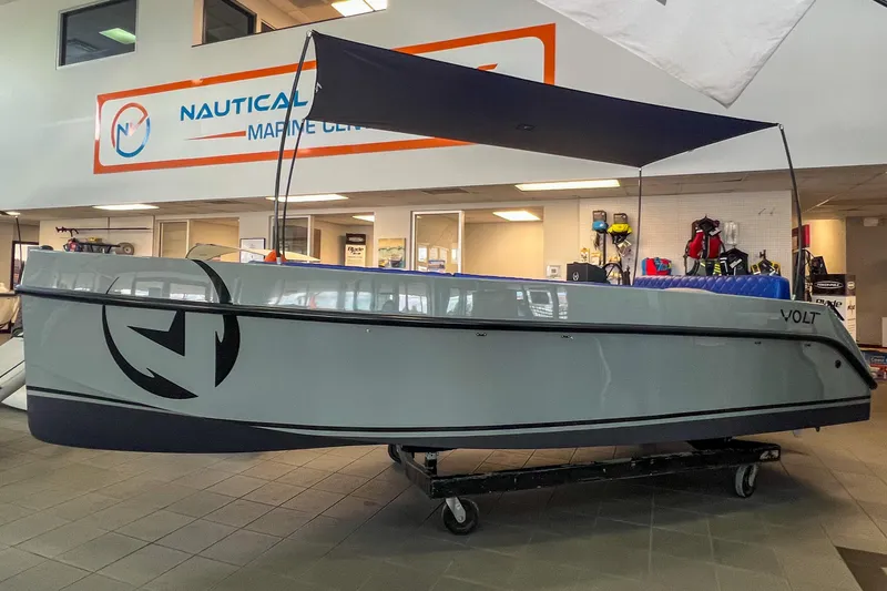 Slide: The Image of 2023 Vision Marine Technologies Volt 180 boat displayed indoors at a marine center. - 1