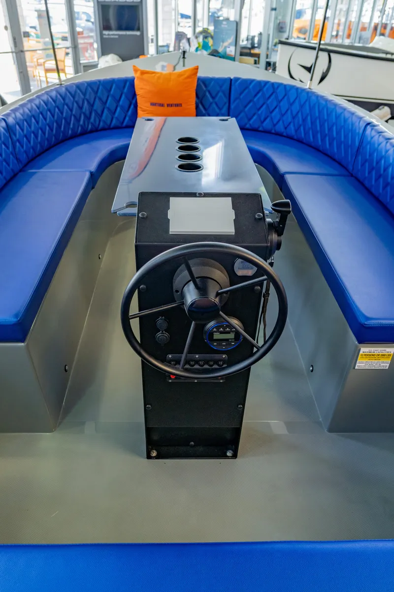 Slide: The Image of 2023 Vision Marine Technologies Volt 180 boat interior with blue seating and steering console. - 9