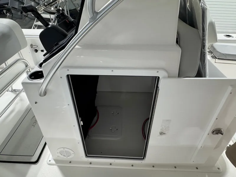 Slide: The Image of 2026 Bay Rider 2260 FS Skiff console storage compartment with open door. - 15