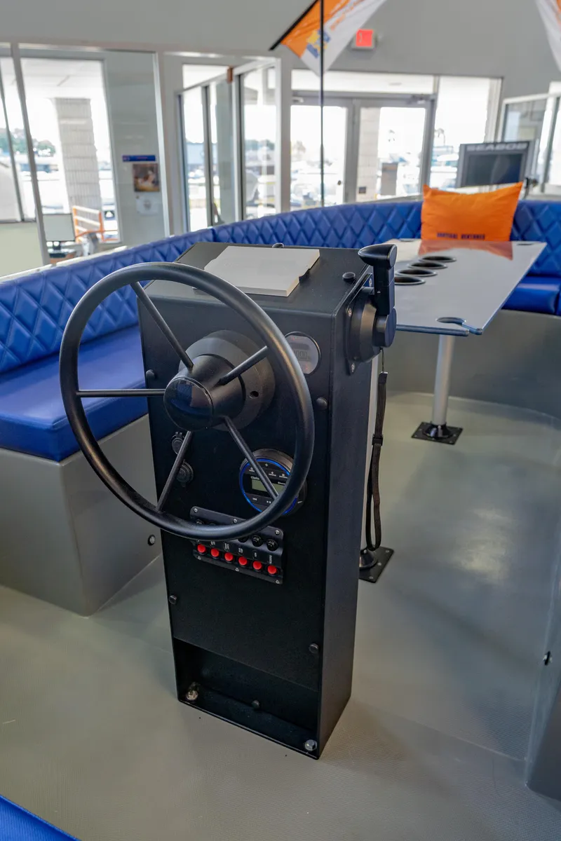 Slide: The Image of 2023 Vision Marine Technologies Volt 180 boat interior with steering wheel and blue seating. - 8