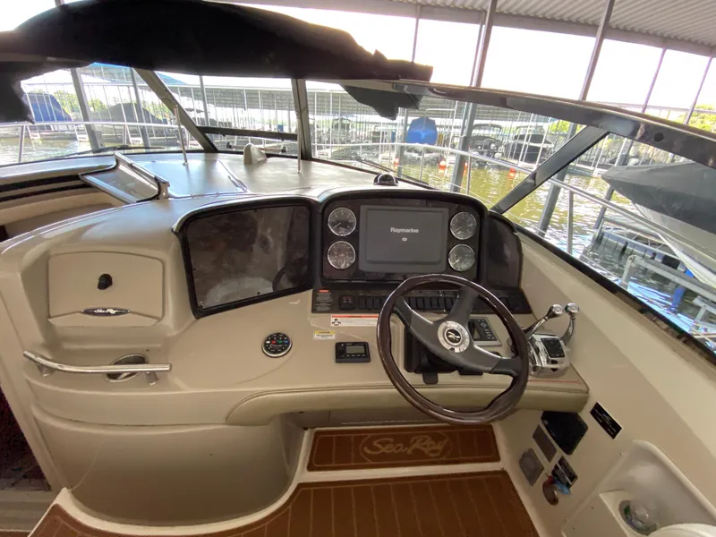 Slide: The Image of 2008 Sea Ray 38 Sundancer helm with steering wheel, Raymarine display, and control panel. - 17