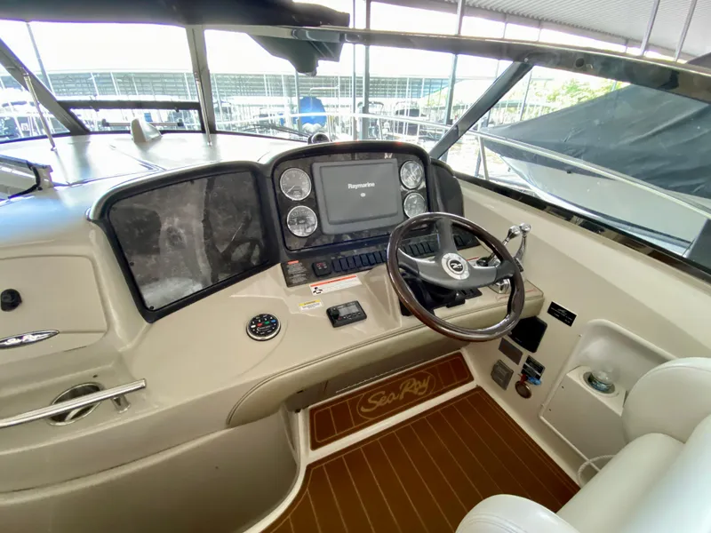 Slide: The Image of 2008 Sea Ray 38 Sundancer helm with steering wheel and navigation controls. - 23