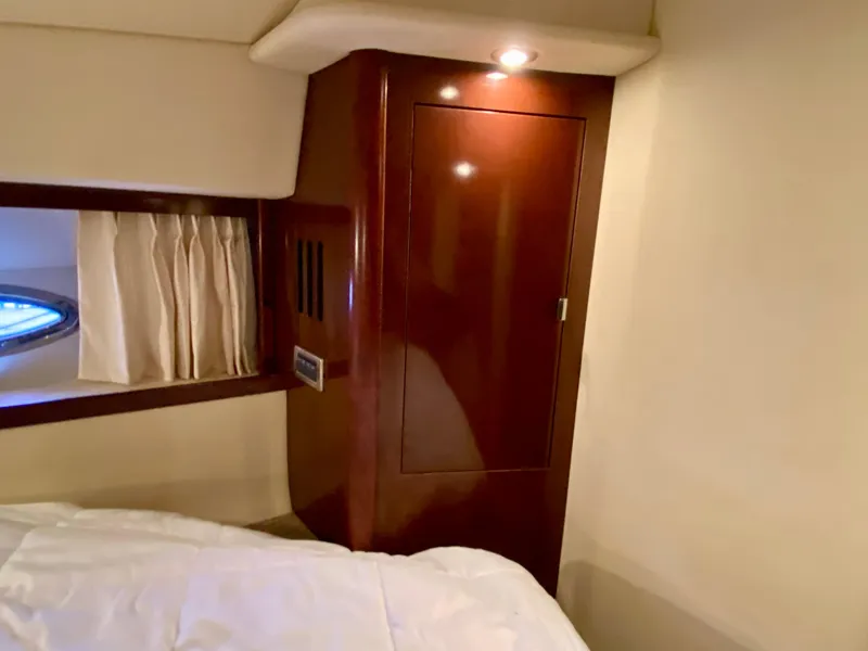 Slide: The Image of Interior cabin of 2008 Sea Ray 38 Sundancer with wooden closet and porthole window. - 33