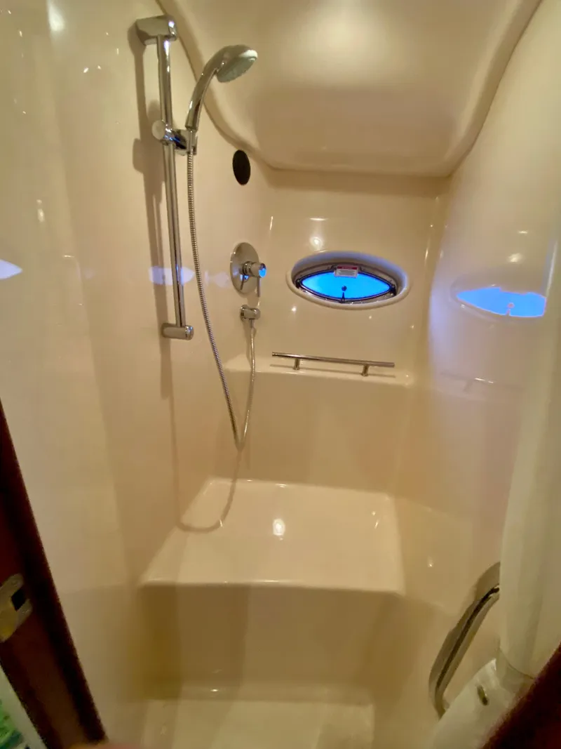 Slide: The Image of Luxurious shower area in 2008 Sea Ray 38 Sundancer yacht, featuring sleek design and porthole window. - 34