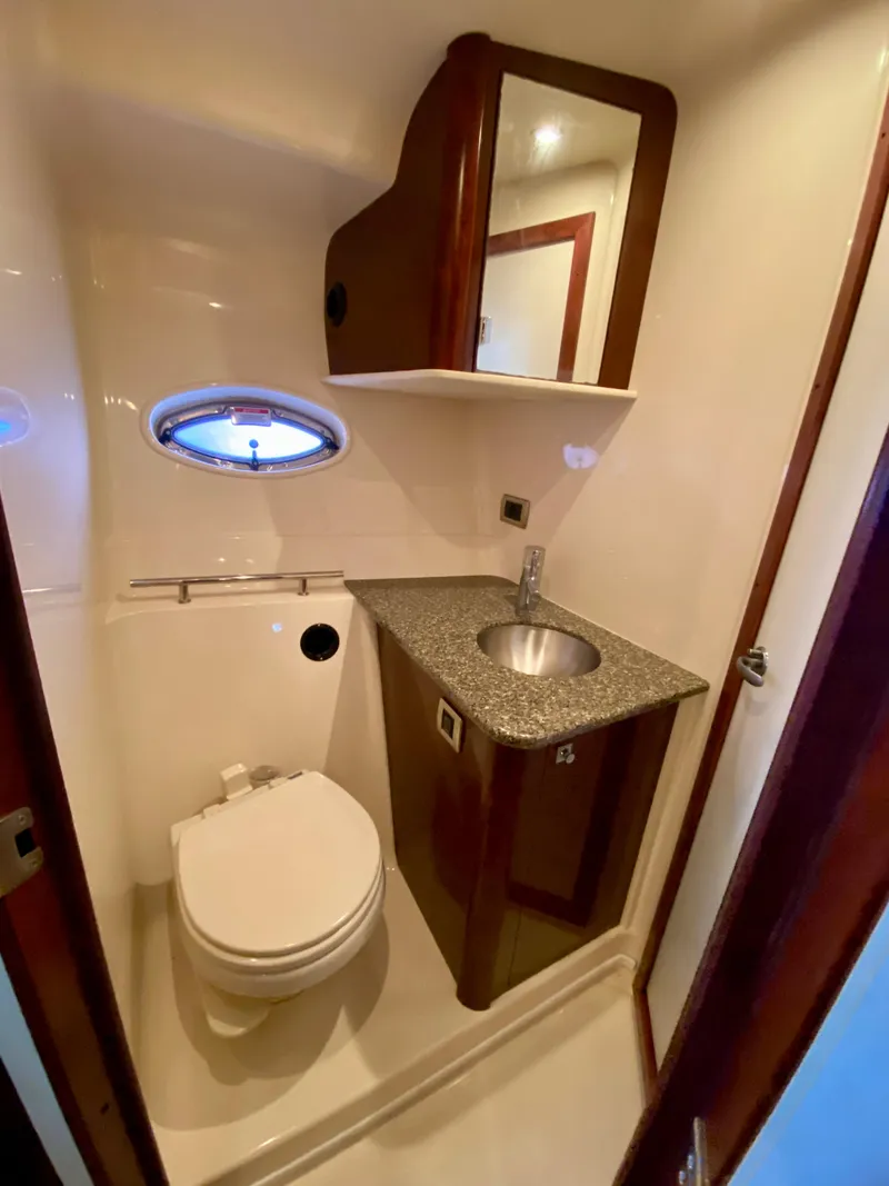 Slide: The Image of 2008 Sea Ray 38 Sundancer bathroom with sink, toilet, and porthole window. - 35