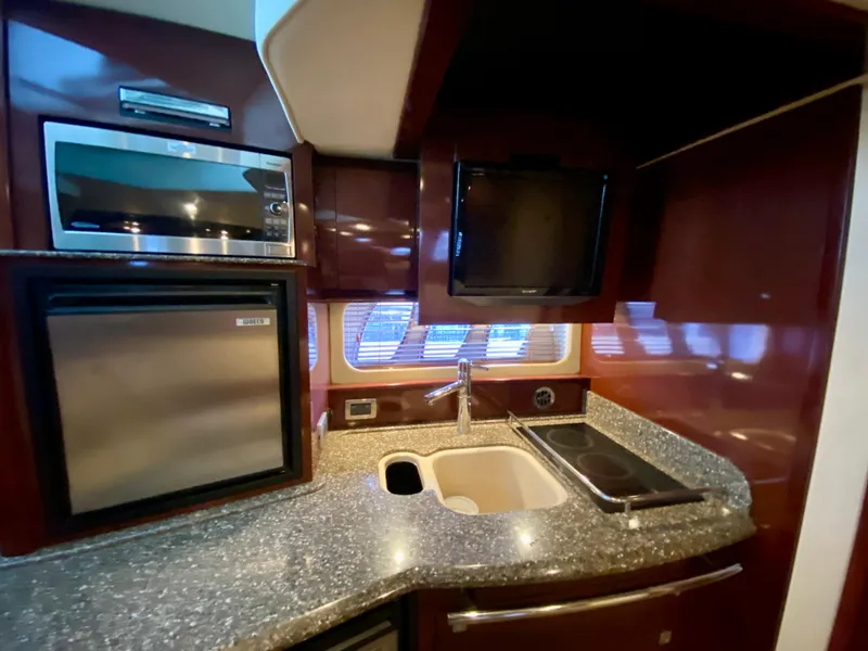 Slide: The Image of 2008 Sea Ray 38 Sundancer kitchen with microwave, sink, and cooktop. - 36