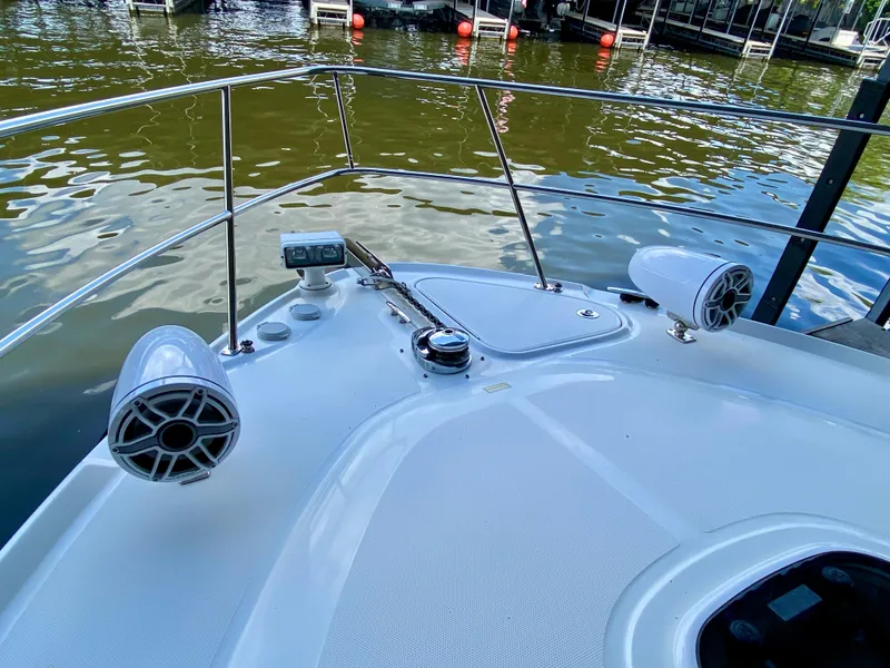 Slide: The Image of 2008 Sea Ray 38 Sundancer boat deck with speakers and railing on calm water. - 8