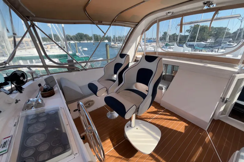 Slide: The Image of 1989 Jefferson 42 Sundeck Motor Yacht helm with dual seats and marina view. - 27