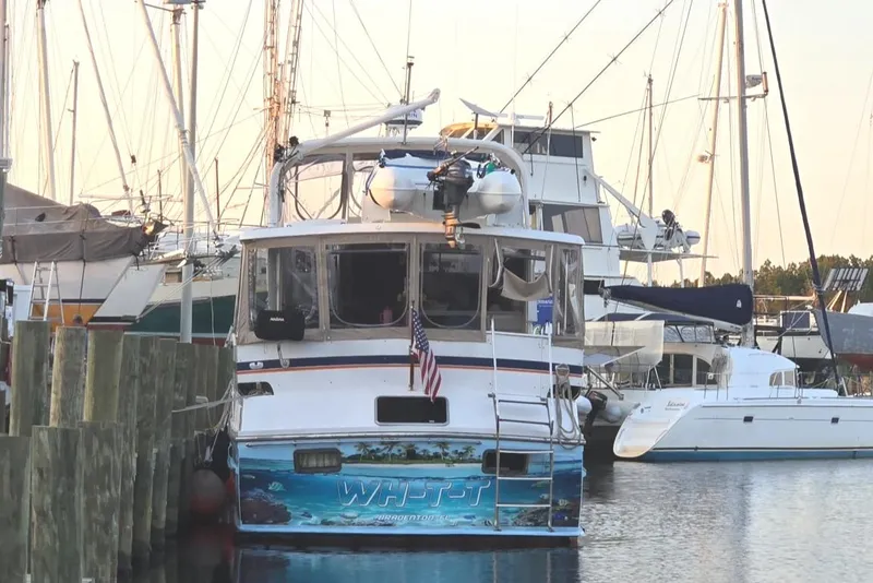 Slide: The Image of 1989 Jefferson 42 Sundeck Motor Yacht docked at marina, displaying American flag. - 3