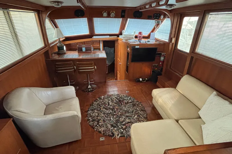 Slide: The Image of 1989 Jefferson 42 Sundeck Motor Yacht interior with cozy seating and wooden accents. - 4