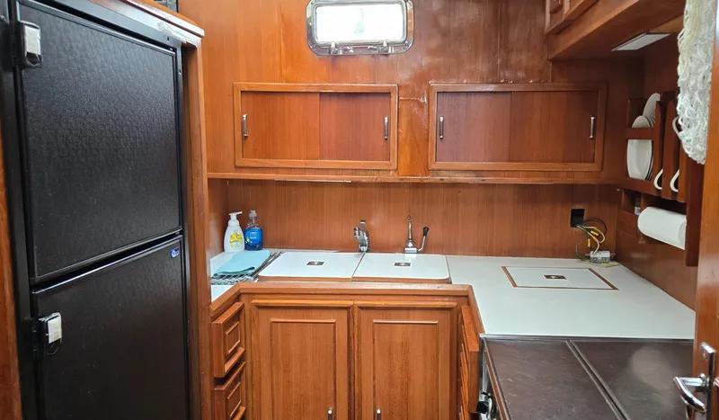 Slide: The Image of 1989 Jefferson 42 Sundeck Motor Yacht kitchen with wood cabinets and dual sinks. - 7