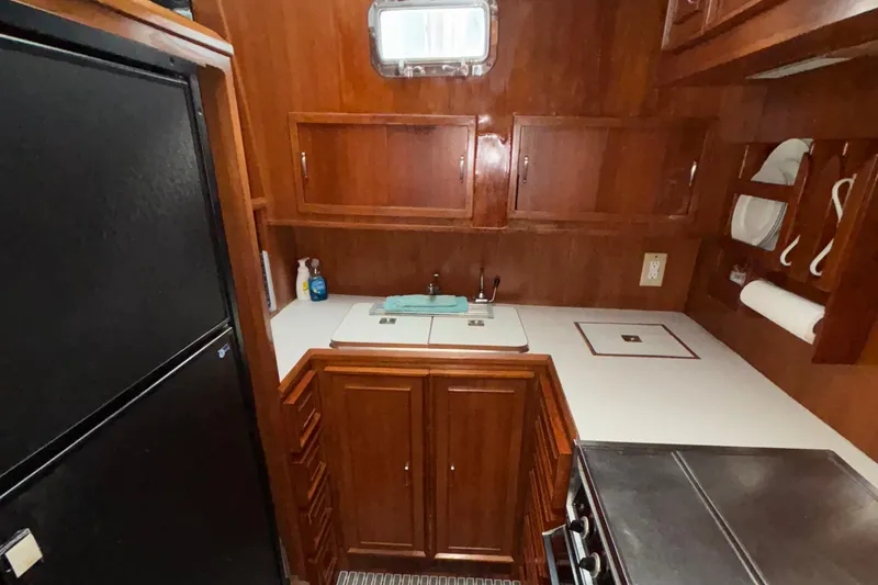Slide: The Image of 1989 Jefferson 42 Sundeck Motor Yacht kitchen with wooden cabinets and modern appliances. - 9