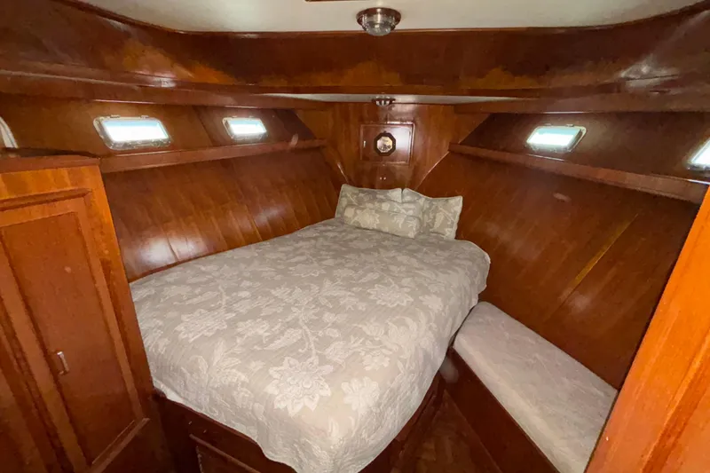 Slide: The Image of 1989 Jefferson 42 Sundeck Motor Yacht cabin with wood paneling and cozy bed. - 10