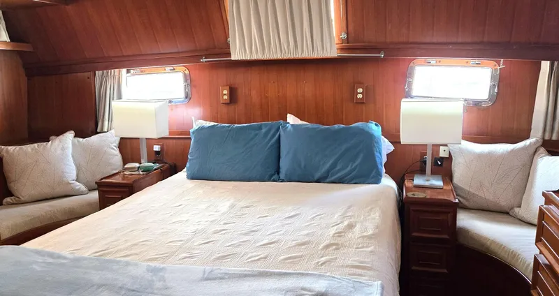 Slide: The Image of Cozy bedroom in 1989 Jefferson 42 Sundeck Motor Yacht with wood paneling and plush bedding. - 15