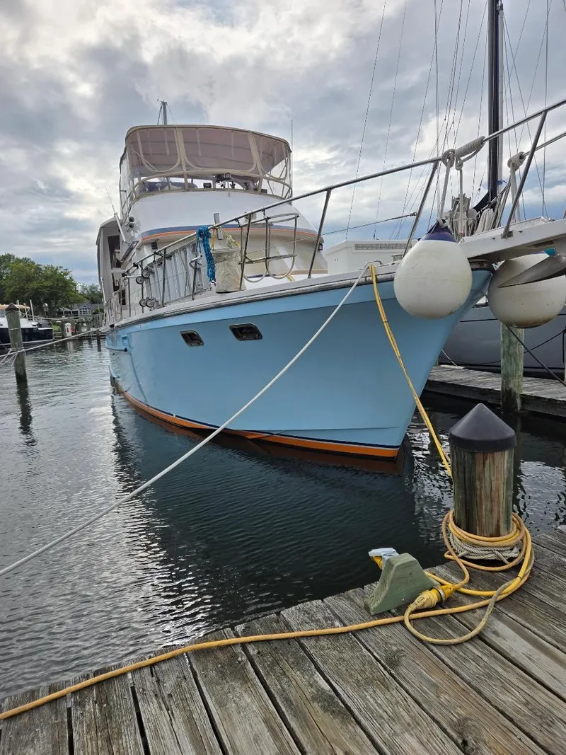 Slide: The Image of 1989 Jefferson 42 Sundeck Motor Yacht docked at marina, cloudy sky background. - 2