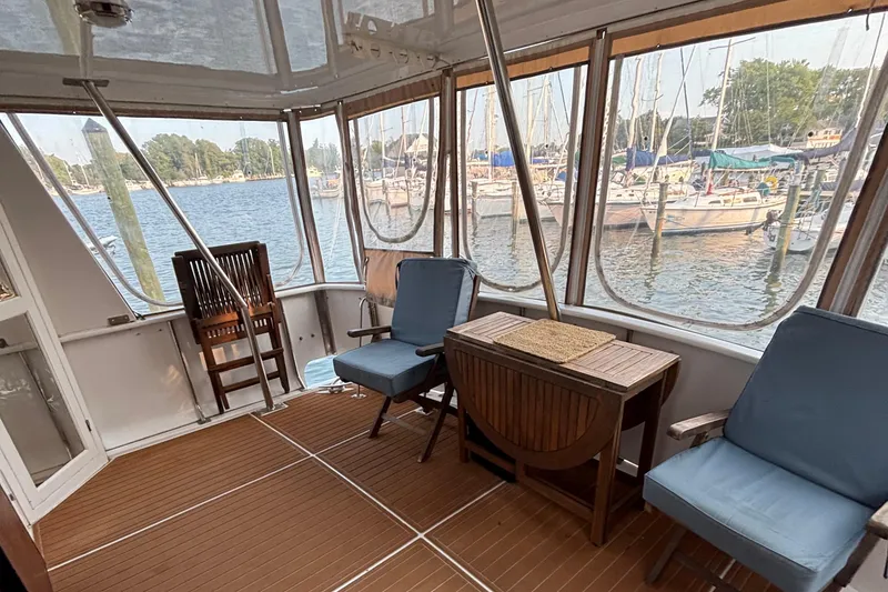 Slide: The Image of 1989 Jefferson 42 Sundeck Motor Yacht interior with chairs and table, overlooking marina. - 22