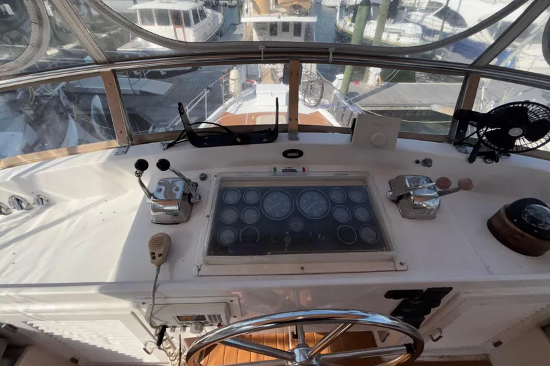 Slide: The Image of 1989 Jefferson 42 Sundeck Motor Yacht helm with gauges, controls, and steering wheel. - 24