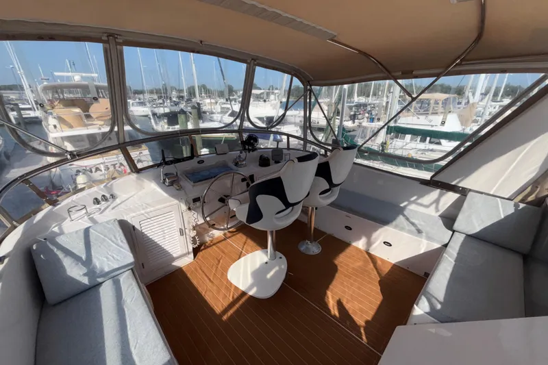 Slide: The Image of 1989 Jefferson 42 Sundeck Motor Yacht interior with helm, seating, and marina view. - 28