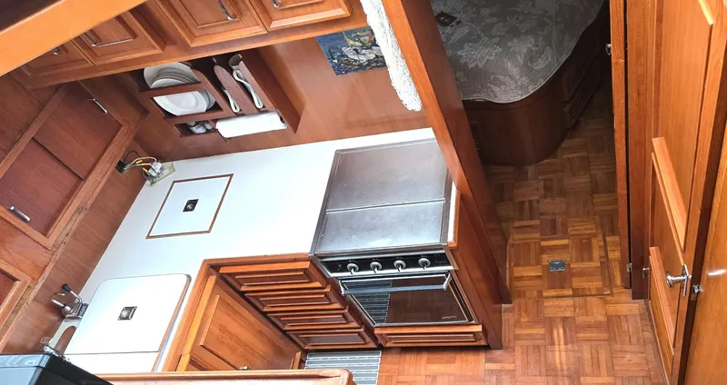 Slide: The Image of 1989 Jefferson 42 Sundeck Motor Yacht interior with wood cabinetry and compact kitchen area. - 6