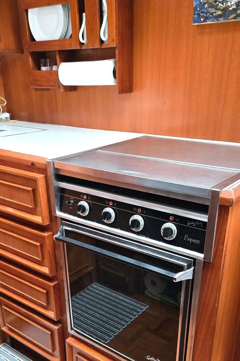 Slide: The Image of 1989 Jefferson 42 Sundeck Motor Yacht kitchen with wooden cabinetry and built-in oven. - 8