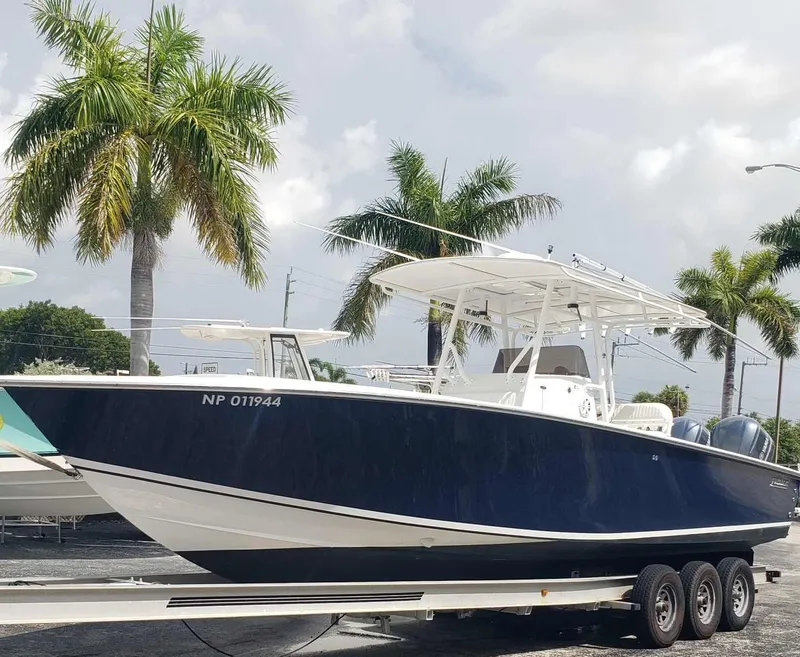 Slide: The Image of 2003 Jupiter 31 Center Console boat on trailer, surrounded by palm trees. - 0