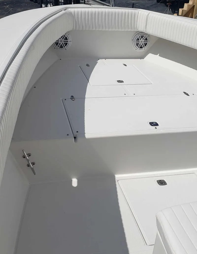 Slide: The Image of 2003 Jupiter 31 Center Console boat interior with white seating and storage compartments. - 11