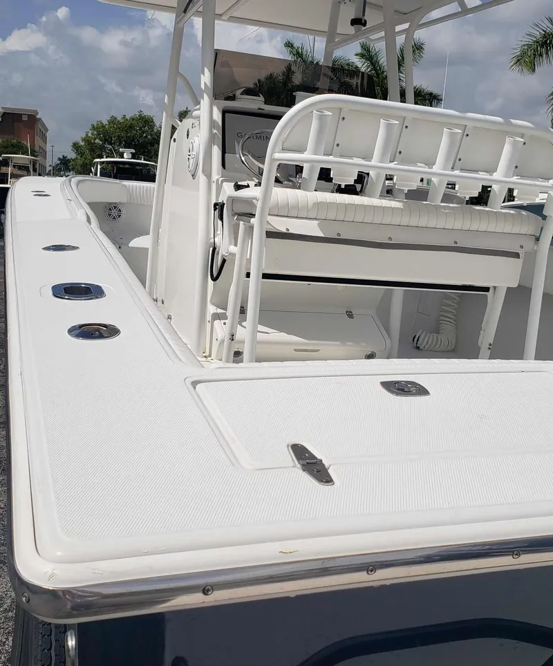 Slide: The Image of 2003 Jupiter 31 Center Console boat with seating and rod holders, under a clear sky. - 12