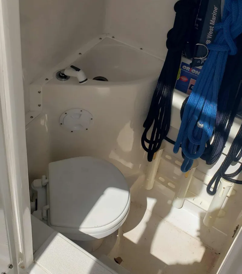 Slide: The Image of 2003 Jupiter 31 Center Console boat interior with toilet and storage area. - 13