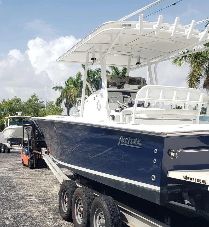 Slide: The Image of 2003 Jupiter 31 Center Console boat on trailer, palm trees in background. - 2