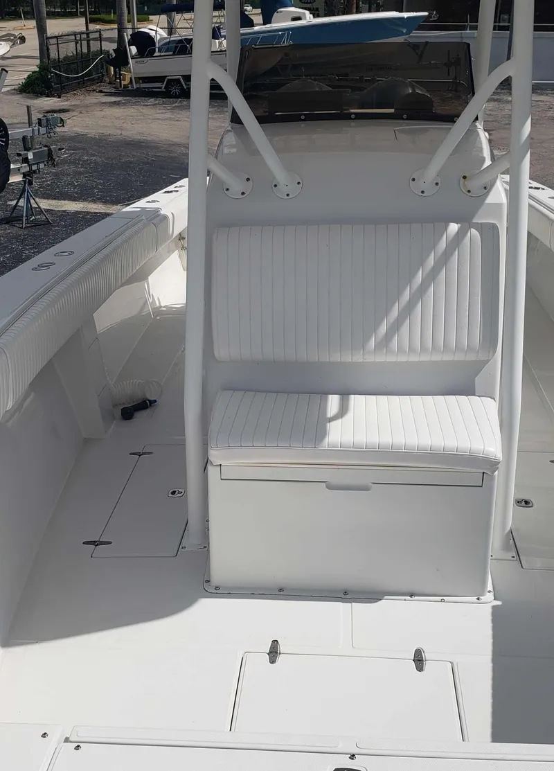 Slide: The Image of 2003 Jupiter 31 Center Console boat interior with white seating and storage compartments. - 6