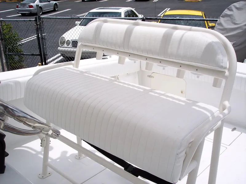 Slide: The Image of 2003 Jupiter 31 Center Console boat seating with white upholstery in a parking lot setting. - 8
