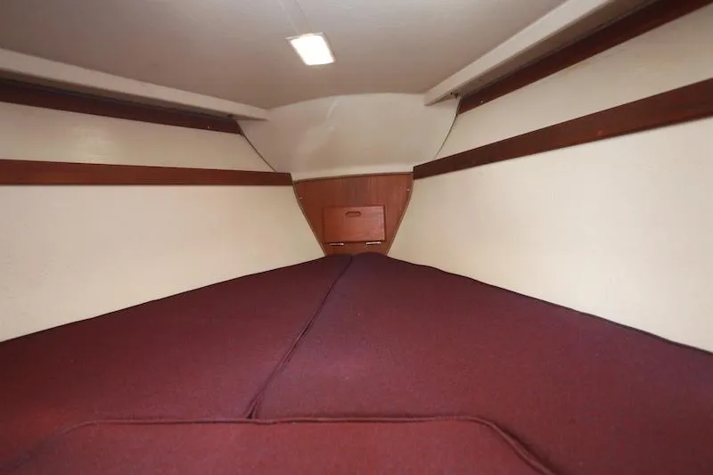Slide: The Image of Interior cabin of a 1985 Catalina 30 sailboat with maroon bedding. - 11