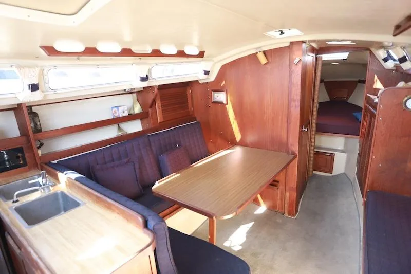 Slide: The Image of Interior of a 1985 Catalina 30 sailboat with wood finish and cozy seating area. - 4
