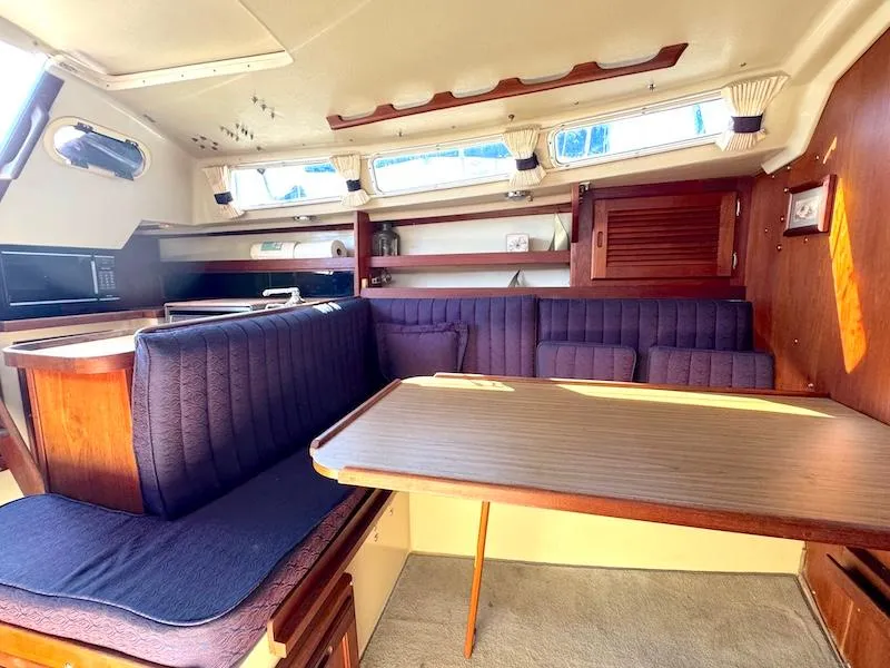 Slide: The Image of Interior of a 1985 Catalina 30 sailboat with cozy seating and wooden table. - 5