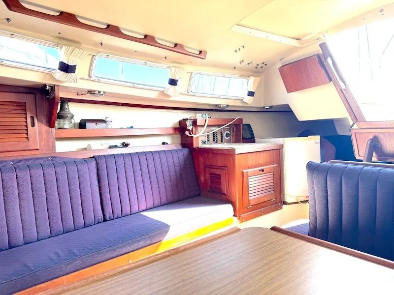 Slide: The Image of Interior of a 1985 Catalina 30 sailboat with blue seating and wooden cabinetry. - 6