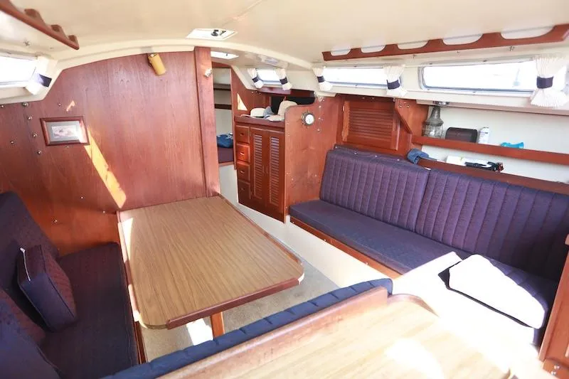 Slide: The Image of Interior of a 1985 Catalina 30 sailboat with wooden furnishings and seating area. - 7
