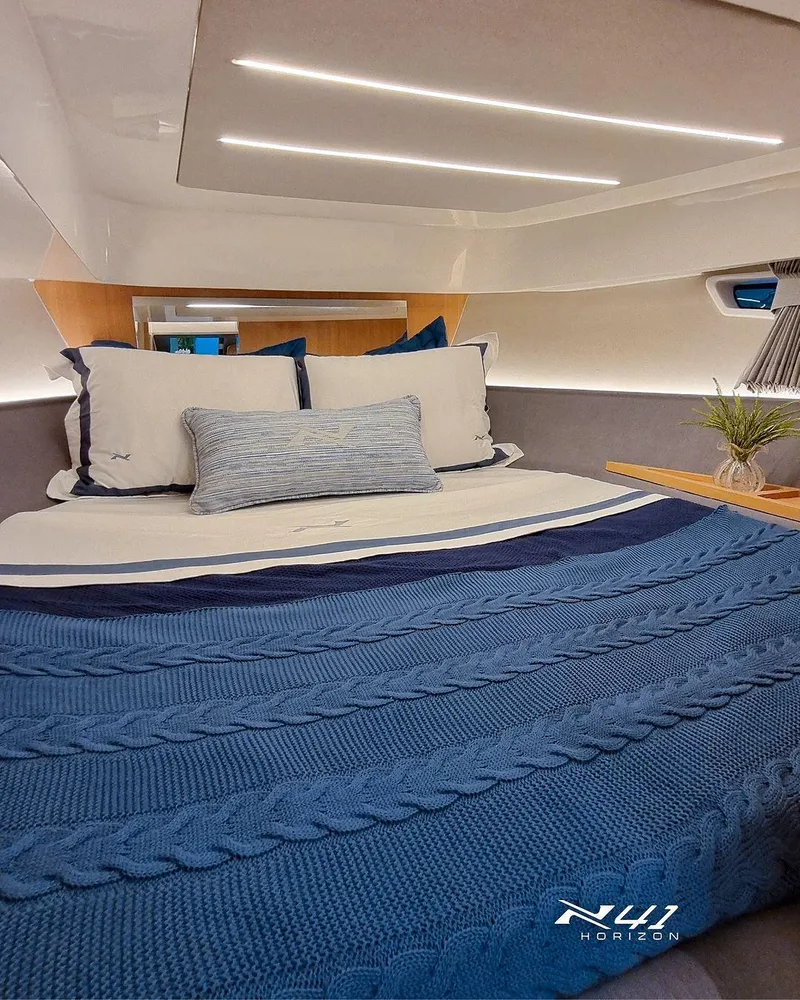 Slide: The Image of Luxurious interior of 2025 NX Boats NX41 HORIZON with elegant bedding and modern lighting. - 6